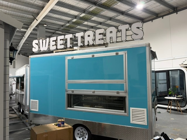 Light blue custom food trailer — rear view with service window
