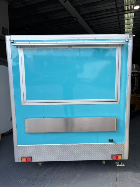 Teal blue custom food trailer — side view with service door