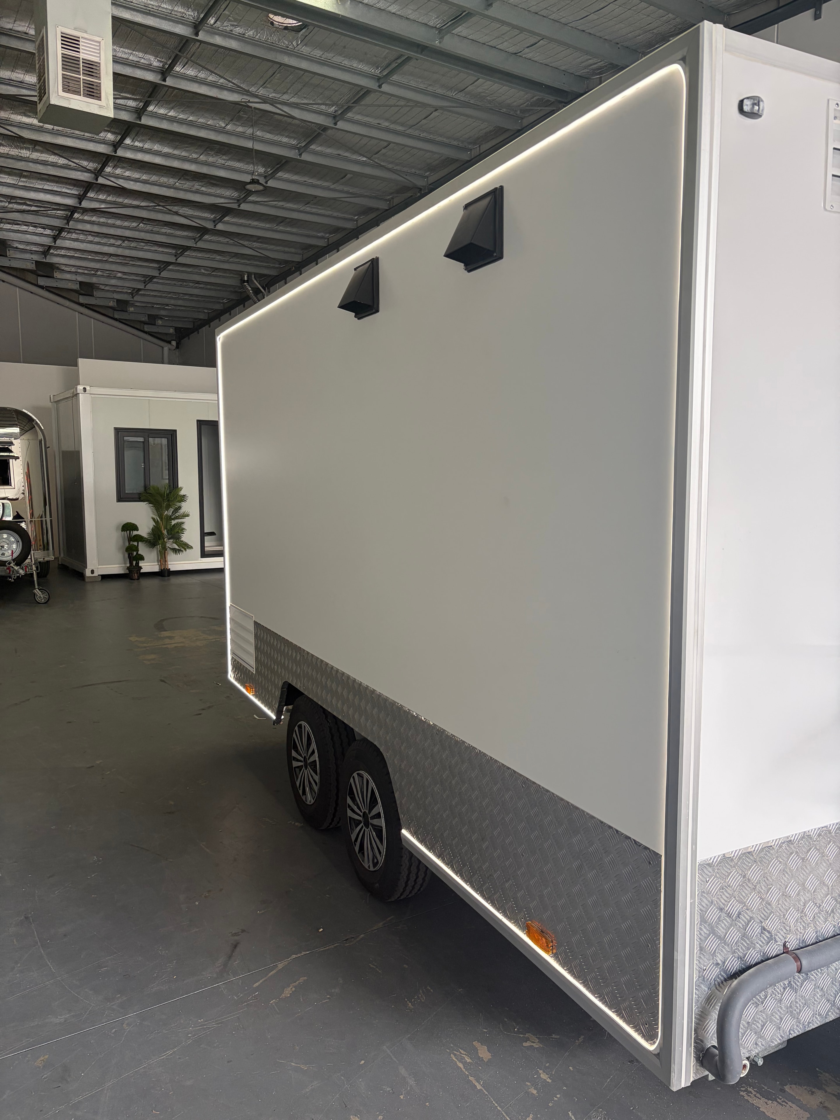 Interior display fridge with blue LED lighting and stainless steel kitchen fitout