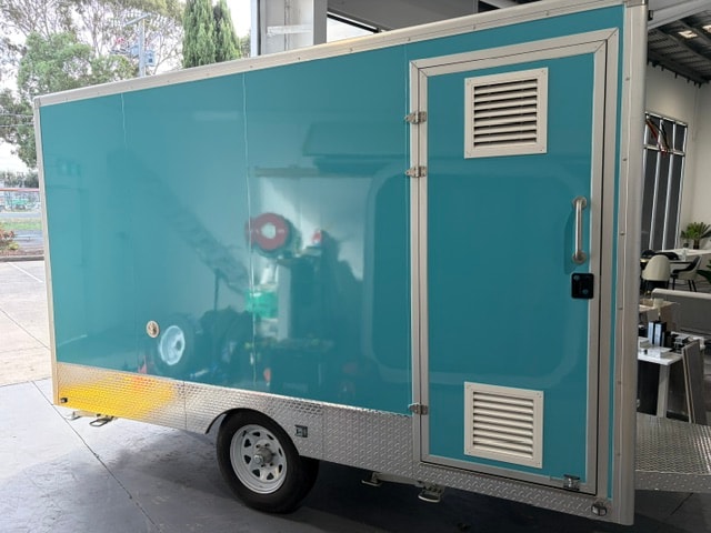 Blue Sweet Treats branded food trailer inside showroom