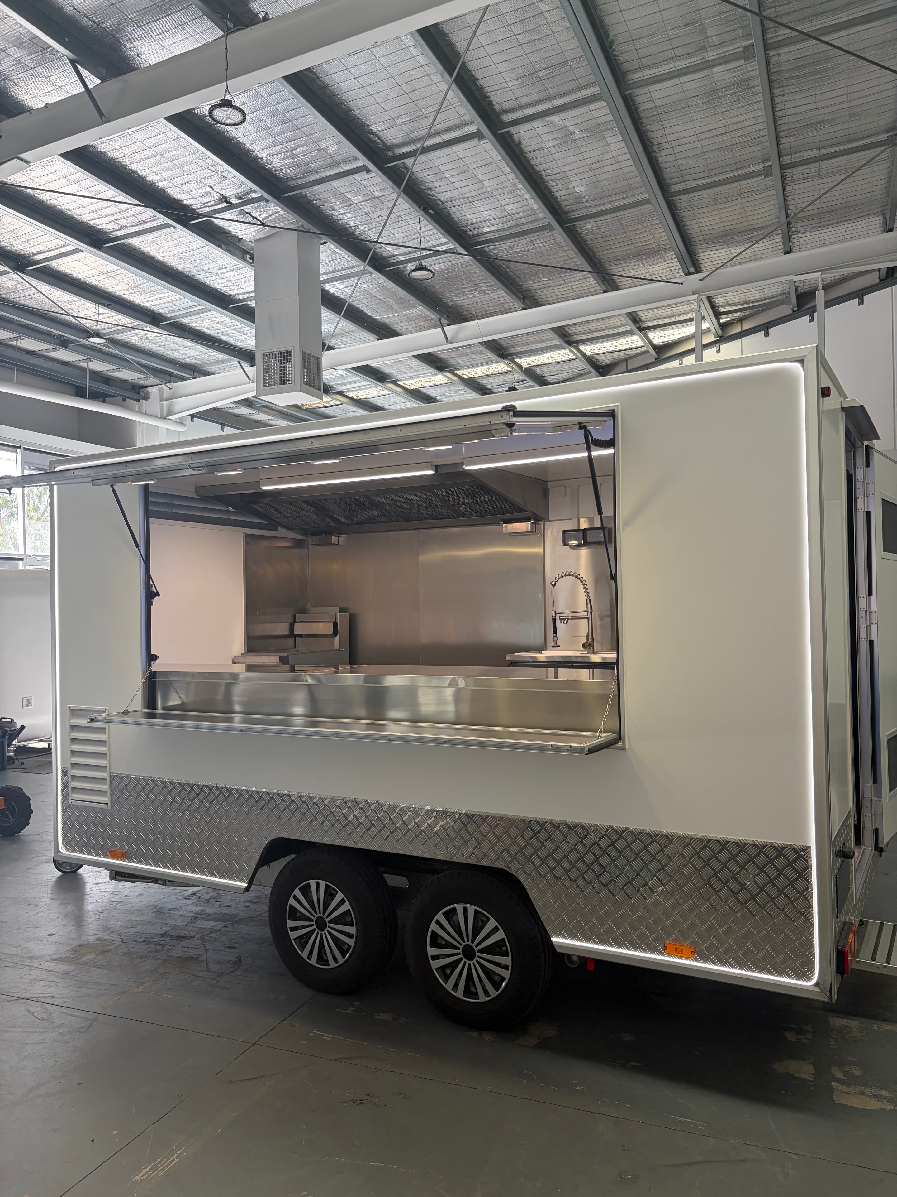 Rear panel of food trailer showing ventilation louvres, tail lights and checker plate trim
